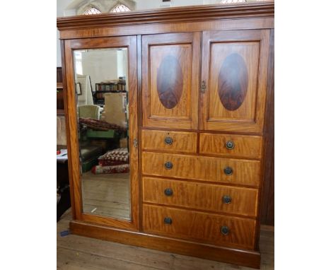 An Edwardian mahogany and inlaid wardrobe, with mirror door, a pair of cupboard doors opening to reveal linen drawers, over t
