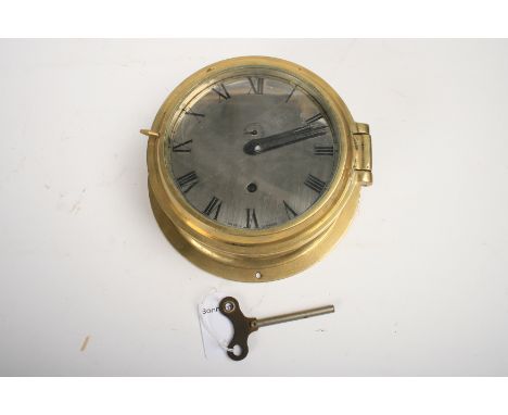 A German brass bulkhead clock,brass case with hinged lid, polished nickel dial with Roman numerals and subsidiary seconds dia