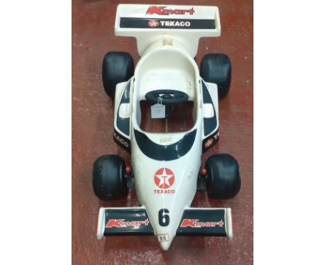 A plastic bodied K-Mart Indy pedal car,1980s, white moulded bodywork with stickers, 120cm long. This lot is subject to the fo