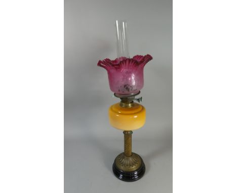 A Victorian Oil Lamp with Opaque Yellow Glass Reservoir and Brass Support Together with Etched Cranberry Glass Shade and Plai