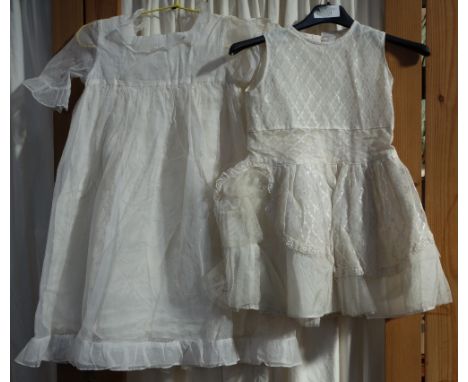 A CHILD'S WHITE NET VINTAGE PARTY DRESS and another similar decorated with spots and white applique flowers (2)