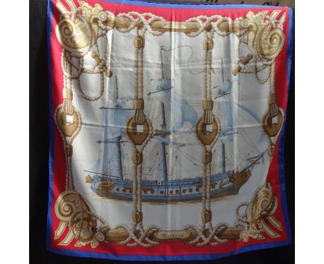 HERMES: A vintage square hand rolled silk scarf 'Tribord' depicting a sailing boat, navy blue border with red  surround, 90cm