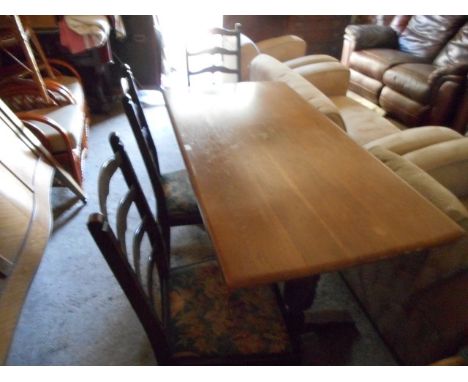 An Ercol-type oak dining table and a set of three ladder back dining chairs.
