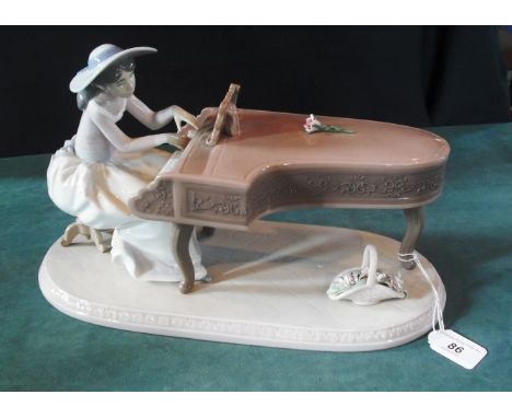 A Lladro figure, modelled as a young woman seated at a spinet, 21cm high.