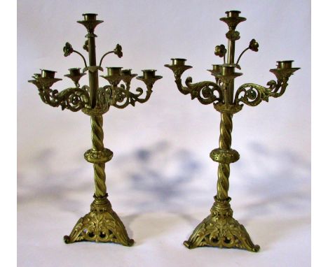 A pair of 19th century seven light gilt brass ecclesiastical candelabra, with scrolling branches and floral finials, raised o