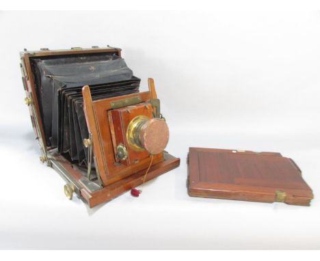An antique Thornton Pickard mahogany bellows camera with brass fittings and two double sided photo plates 