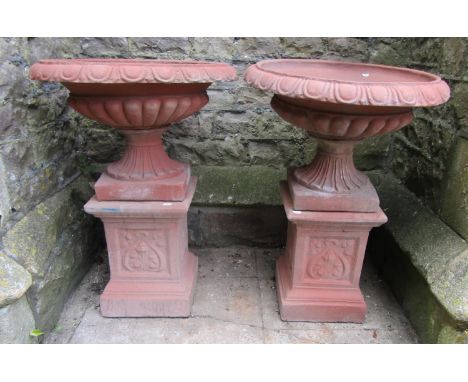 A pair of cast composition stone classical design faux terracotta garden urns, the squat circular lobbed bowls with egg and d
