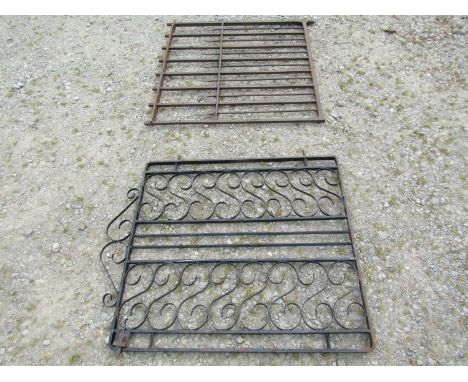 A heavy gauge ironwork garden gate, with open vertical rails, 94cm high, 96 wide together with one other with open scroll wor