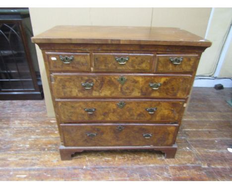 An 18th century and later chest of three short and three long drawers in walnut and burr walnut, with brass handles and escut