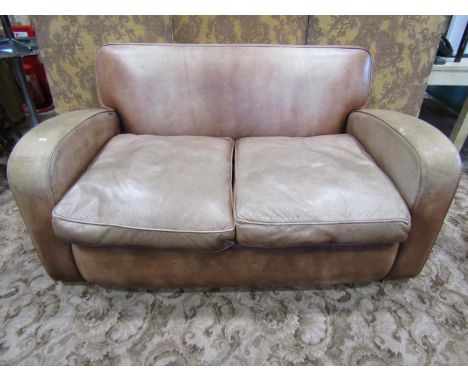 A leather covered tub two seat sofa, with club wing arms, in the Art Deco style, covered in weathered tan leather, 82cm high,
