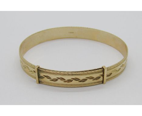 9ct adjustable bangle with engraved foliate decoration, maker 'LW', London, 16.4g 