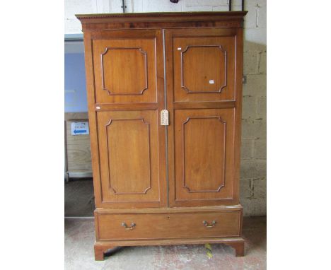 An Edwardian mahogany wardrobe in the Georgian style, enclosed by a pair of three quarter length moulded panelled doors over 
