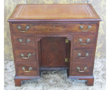 A good quality mahogany kneehole writing desk of diminutive proportions in the George III style with inset tooled leather top