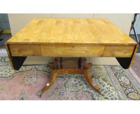 A Regency drop leaf sofa table of rectangular form with one real and one dummy frieze drawer, set on a quadruped base with tu