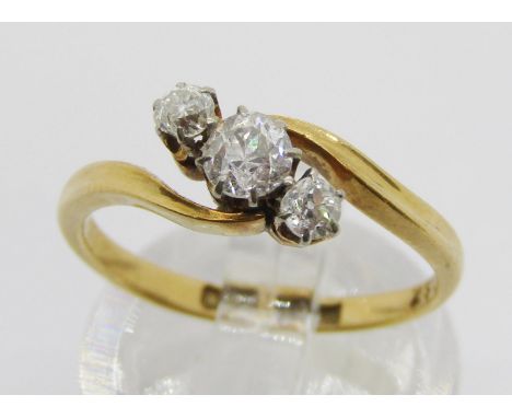 18ct three stone diamond crossover ring, centre stone 0.20ct approx, maker 'W&amp;F.R', size K/L, 2.6g 
