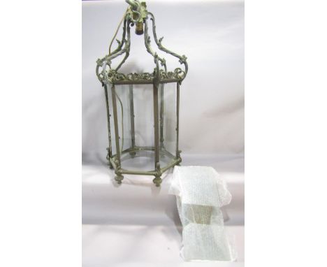 A large antique weathered brass framed hexagonal porch lantern with clear glazed panels with scrolling pierced framework and 