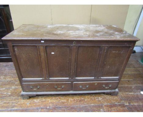 A Georgian oak mule chest of four panels, rising lid and two frieze drawers raised on bracket supports, 132cm x 55cm x 87cm h