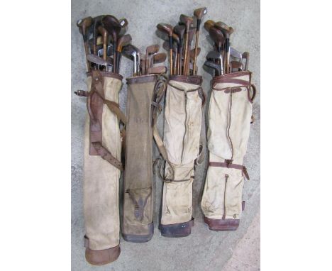Four vintage canvas and leather golf bags containing a collection of hickory shafted golf clubs (various makers) (as per phot
