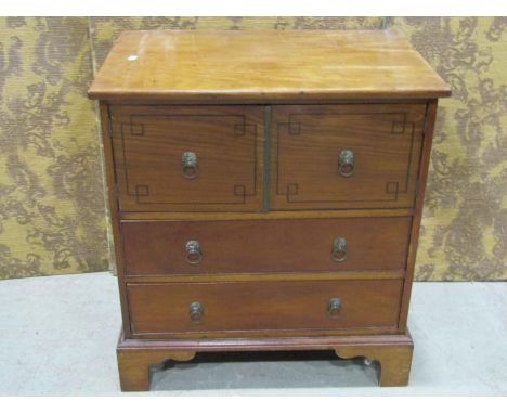 A Regency mahogany bedside cabinet enclosed by cupboard doors and drawers with lion mask and ring handles on bracket  support