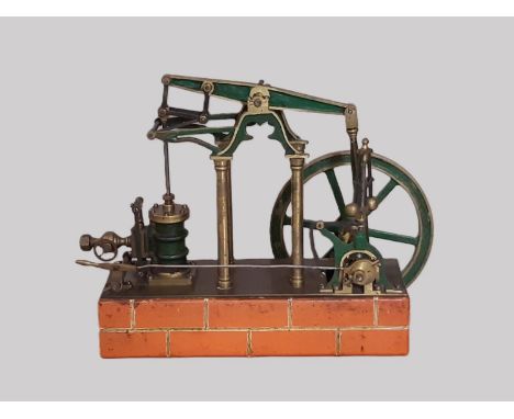 A well engineered live steam model of a stationary 4 column condenser beam engine on brick effect base. Height 21cm. Untested