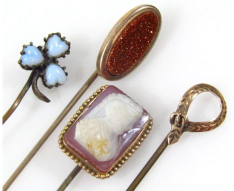 Four various early 20thC stick pins, to include a cameo example 7cm high, etc., unmarked. (4) 
