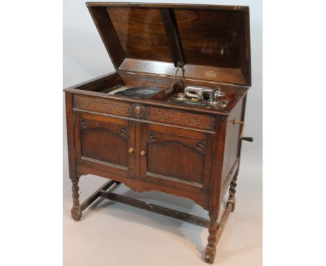 A mid 20thC Concerto free standing gramophone, the compressed caddy lid hinged to reveal a baize lined turn table with articu