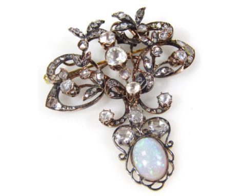 A diamond and opal set pendant/brooch, set with various old cut diamonds in scroll crest design, the higher tier set with row