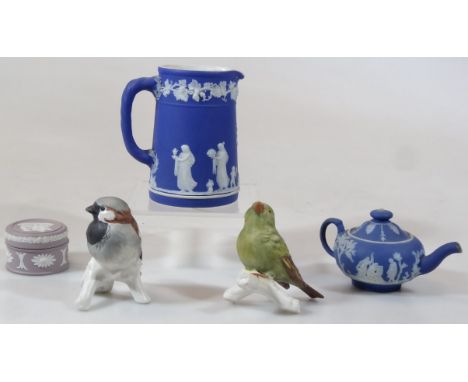 A Wedgwood dark blue Jasperware cream jug, with moulded beak spout, 'C' scroll handle, raised ivy leaf and classical figure b
