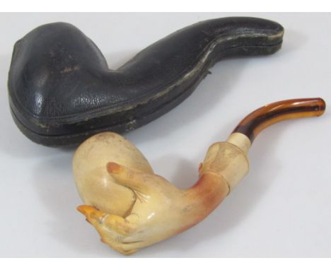 An early 20thC meerschaum pipe, with plain bowl, being held by moulded hand with curved end 16cm wide. (cased)