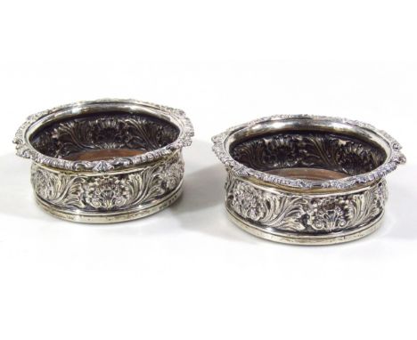 A pair of early 19thC Henley family crested silver coasters, each of circular outline with upper shell and scroll banding, ce