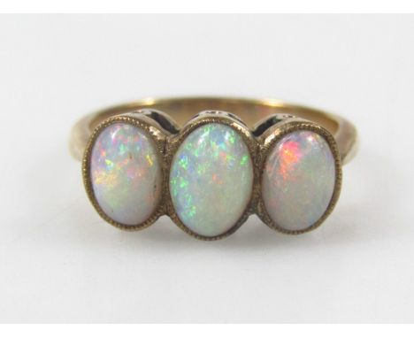 A three stone opal dress ring, set with three opals, in a yellow metal frame, unmarked, 2.9g all in.  