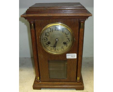 Oak cased steel faced mantel clock with column supports and striking movement 