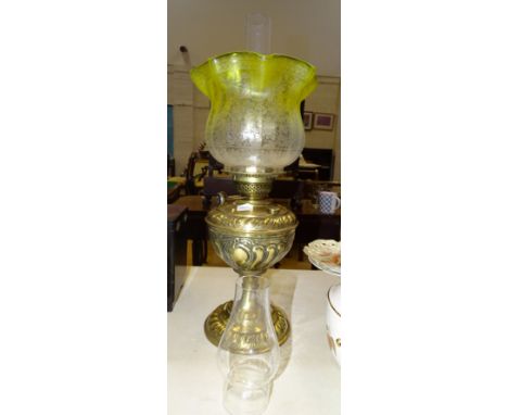 A brass oil lamp with embossed Art Nouveau decoration, with yellow and clear glass etched decorated shade and two chimneys, l