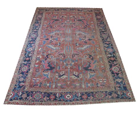 FINE ANTIQUE PERSIAN HERIZ CARPET, 335cm x 228cm, all over design of stylised botanical motifs on a terracotta field within m