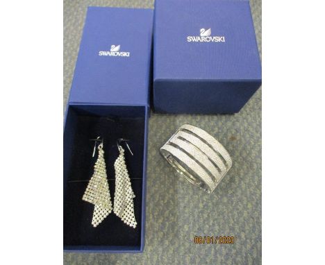 A pair of Swarovski Fit earrings in the form of triangular scarfs, together with a Swarovski crystal bangle, both with brande