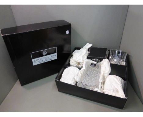 A boxed and unused Royal Doulton crystal decanter and tumbler set.