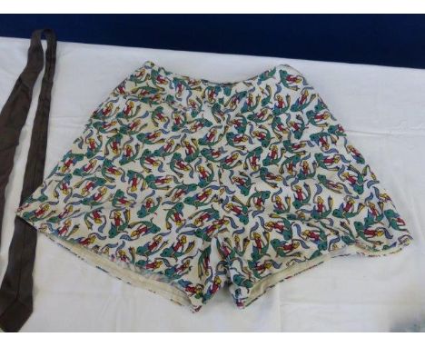 A pair of 1940s/50s linen shorts with repetitive dolphin print and buttons to the side, by Lonoonas; a gentleman's tie decora
