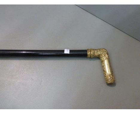 An ebonised walking stick with a heavily embossed gilt handle with name plaque: Robert Bennett, Scarbora Qnt. 