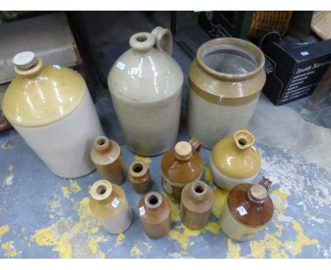 An assortment of stoneware flagons, storage jars and three stoneware bottles including Batey London and R. White etc.
