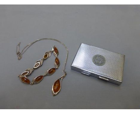 A silver and amber pendant necklace and matching bracelet; also a compact with engine turned decoration. 