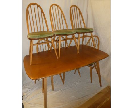 An Ercol light elm rectangular extending dining table with two additional folding centre leaves on turned tapered legs with s