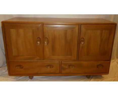 An Ercol light elm sideboard with two base drawers below cupboards enclosed by three panelled doors 51" long