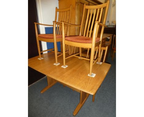 An Ercol light elm dining suite comprising rectangular extending dining table with additional centre leaf on standard support