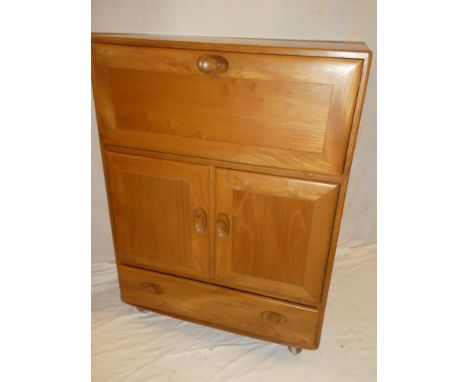 A good quality Ercol light elm upright bureau with fitted compartment enclosed by a fall front above cupboard enclosed by two