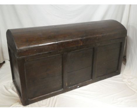 A large good quality Continental stained pine domed top trunk with panelled front 63" long