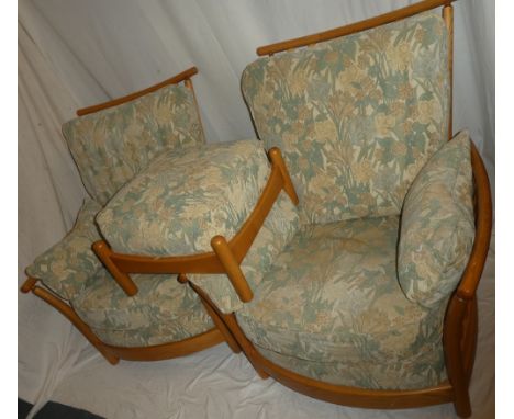 A pair of Ercol light elm ladies and gent's easy chairs with rail backs and sides upholstered in floral fabric together with 