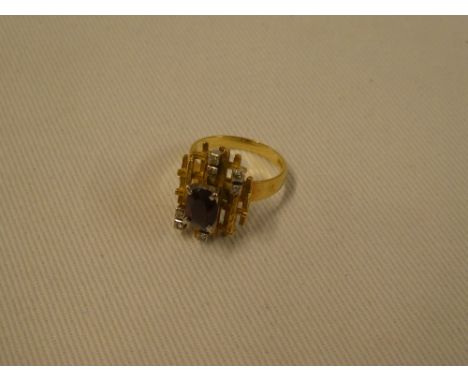 An 18ct gold rustic dress ring set central ruby flanked by eight small diamonds