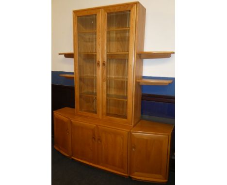 A good quality Ercol light elm four-piece display cabinet/unit with cupboard enclosed by two panelled doors flanked by angled