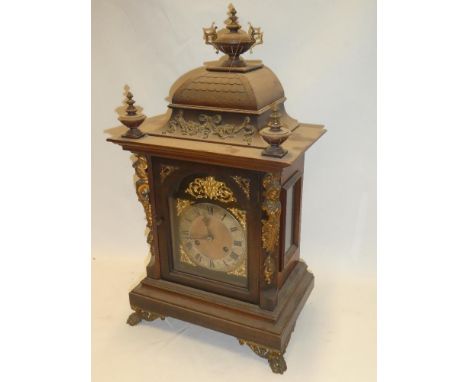 A German bracket clock with gilt and silvered arched dial in brass mounted stained wood tapered case, 22" high