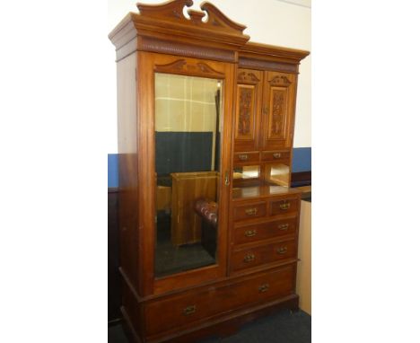 A Victorian carved walnut combination wardrobe by Maple &amp; Co. with hanging compartment enclosed by a bevelled mirror pane